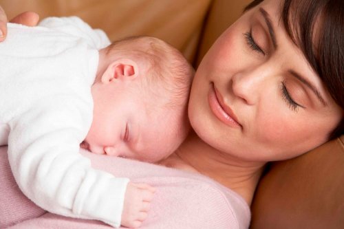 mor der sover med sin baby på sit bryst
