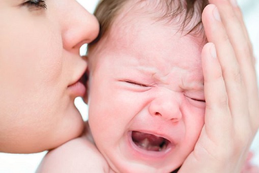 kvinde der kysser grædende baby