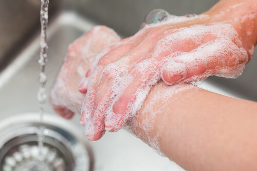 person der vasker hænder grundigt med sæbe