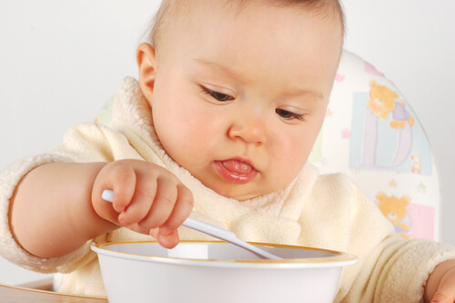 lille baby der spiser med en ske