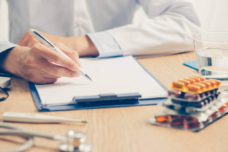 skrivebord hos læge der skriver