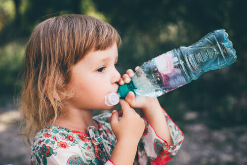 En liten jente som drikker vann.