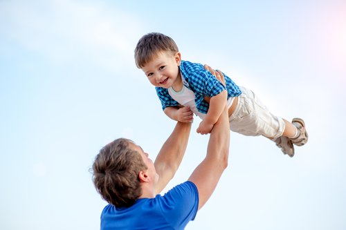 far der løfter dreng op i luften