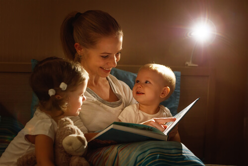 mor der læser godnathistorie for sine to, små børn