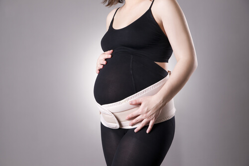 gravid kvinde med støtte rundt om maven
