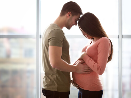 gravid kvinde og mand er står tæt sammen