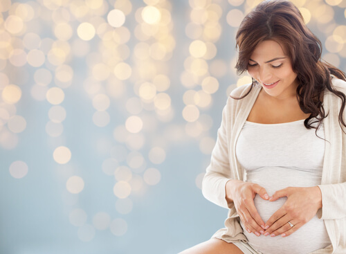 gravid kvinde der former et hjerte på sin mave