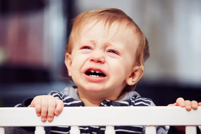 A baby crying in his crib.