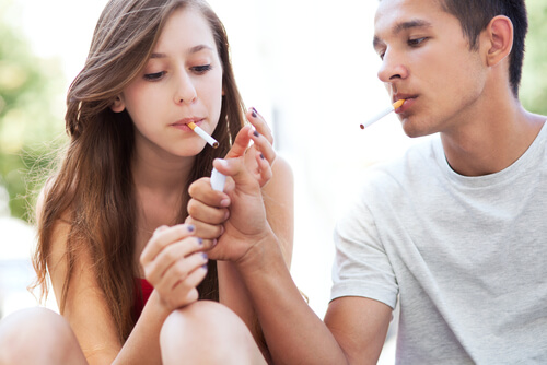 2 unge der tænder en cigaret