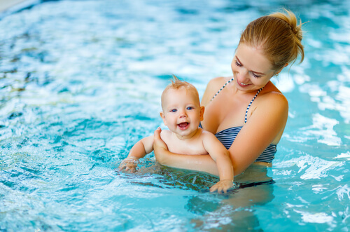 glad baby til svømning med sin mor
