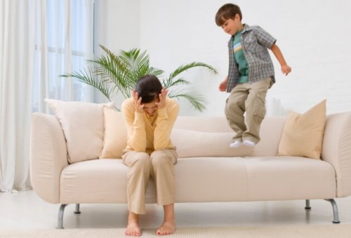 frustreret mor med dreng der hopper i sofa