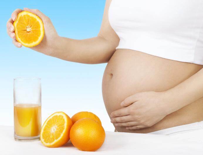 gravid kvinde der presser en appelsin