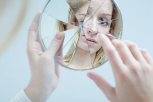 En tenåring ser inn i et ødelagt speil.