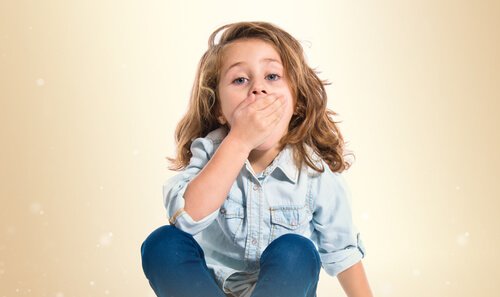 A girl with hand on her mouth.