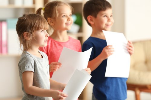 glade børn med papir i hænderne