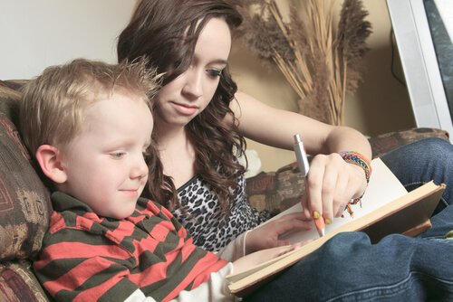 Teen helping a child with reading problems.