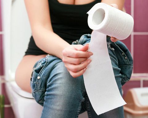 Woman using toilet paper.
