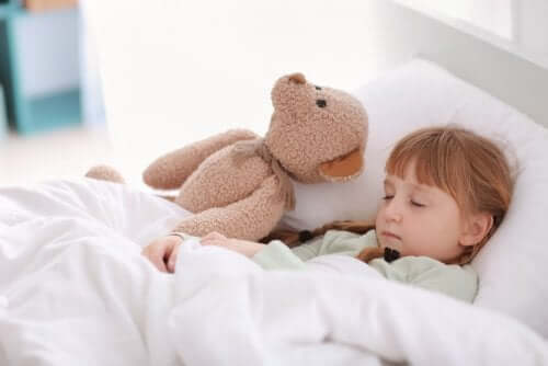 A girl napping with her teddy bear.