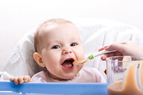A baby eating baby food.