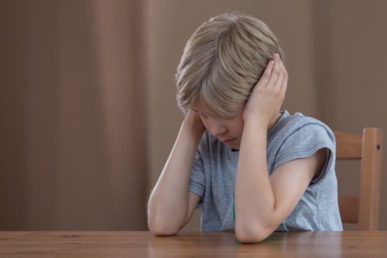 A boy covering his ears.