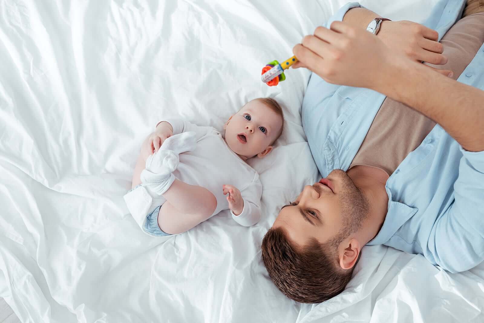 A father and baby playing with a rattle.