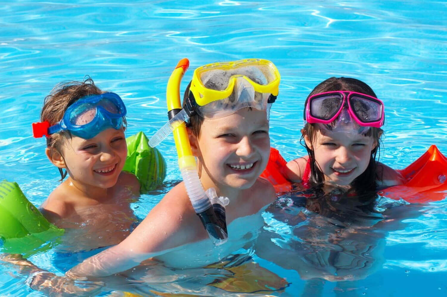 Children playing in a pool with snorkel gear.