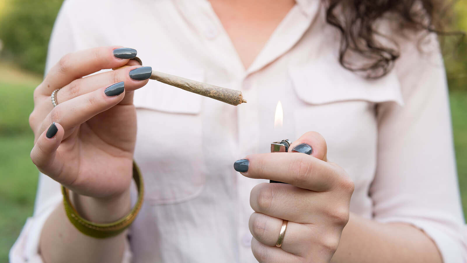 A woman lighting a joint.
