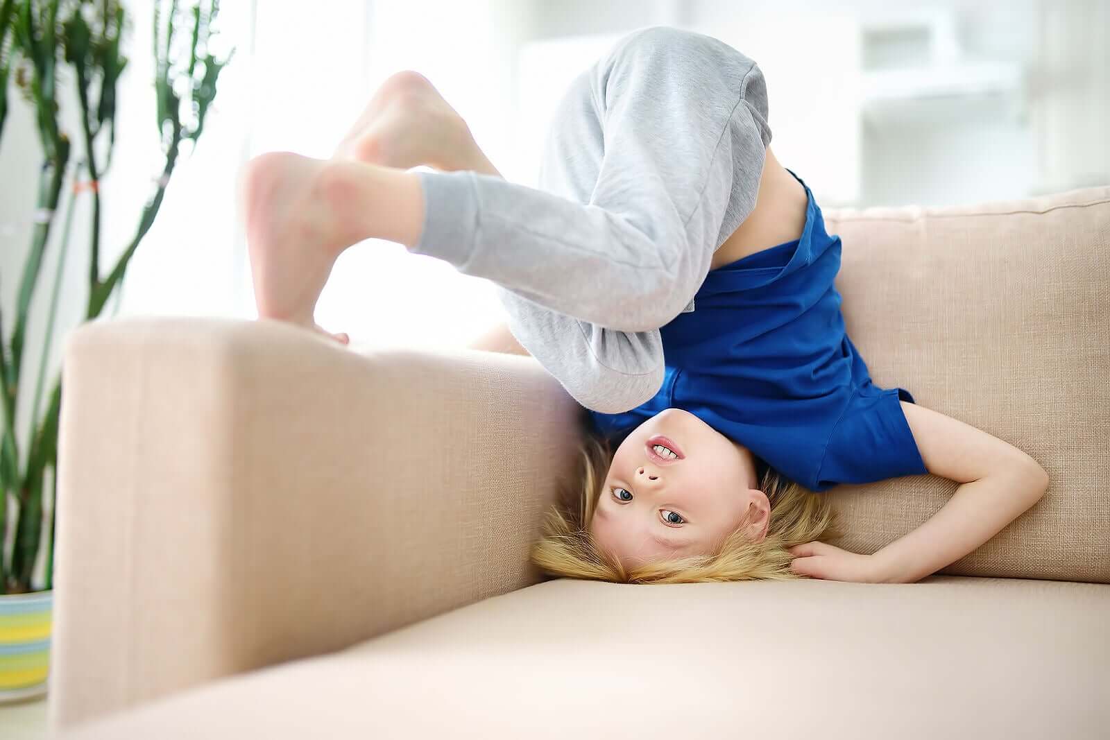 A child tumbling on a couch.