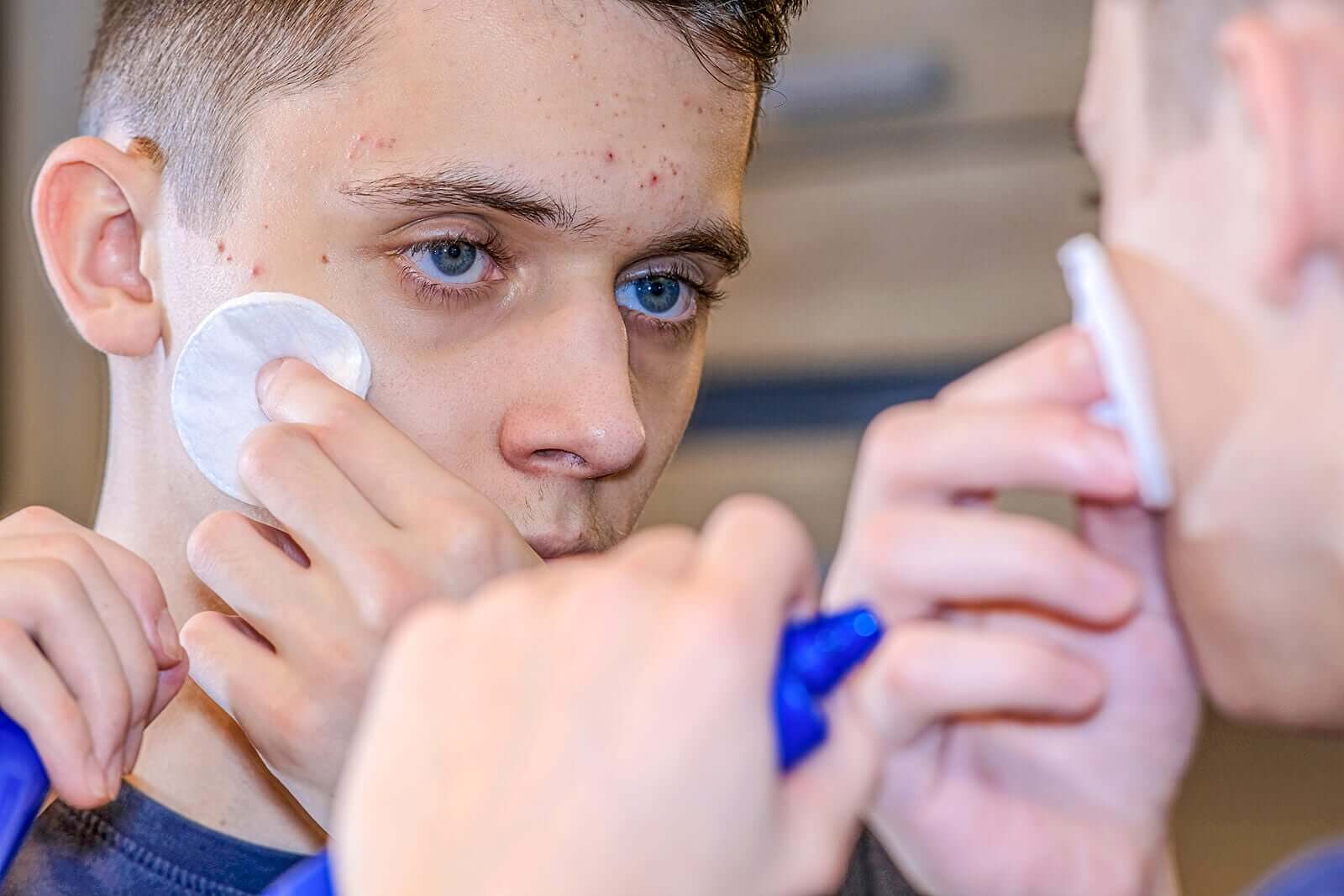 Een tiener maakt zijn gezicht schoon