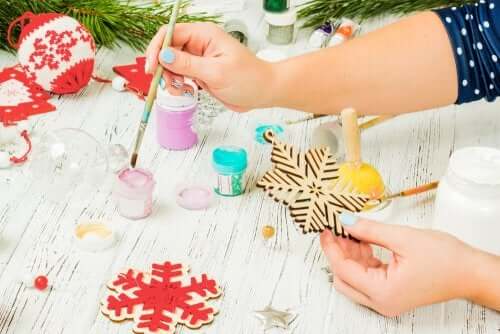 A woman painting a wooden snowflake ornament.