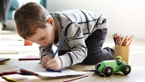 Dreng på gulv nyder fordelene ved at tegne