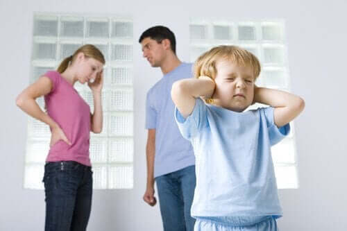Barn holder sig for ørerne, da forældre skændes i baggrunden, hvilket er eksempel på dysfunktionelle familier