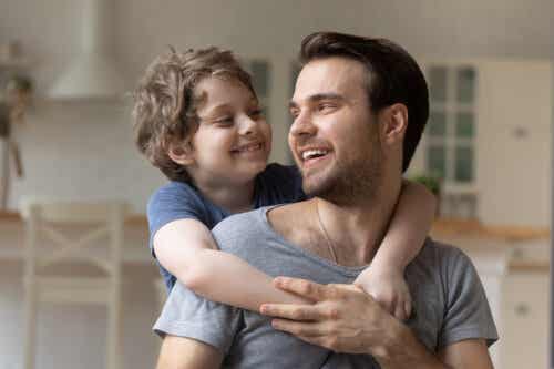 A son with his arms around his dad's neck.