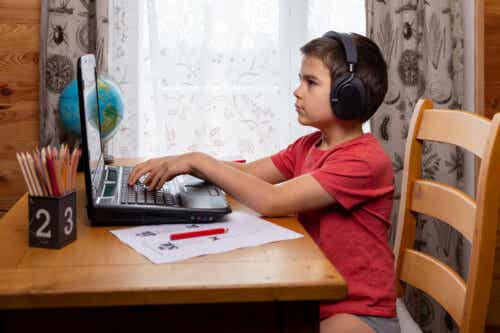 Dreng ved computer er ved at lære at skrive