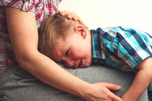 Ein kleiner Junge weint auf dem Schoß seiner Mutter.
