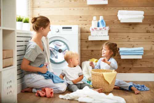 Mor og børn ordner vasketøj som eksempel på livsfærdigheder at lære børn