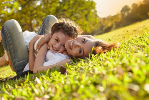 Mor på græs med barn er eksempel på at opdrage glade børn