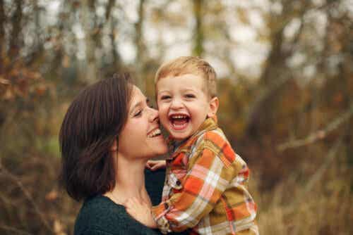 En mor som holder den smilende lille gutten hennes.