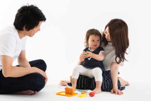 A couple playing on the floor with their toddler daughter.