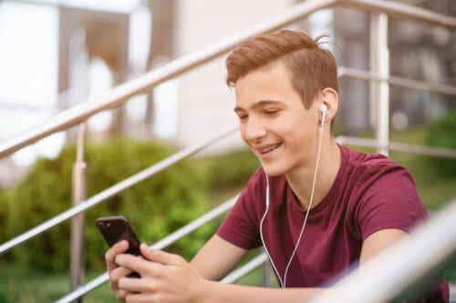 Dreng med telefon nyder fordele ved sociale medier for teenagere