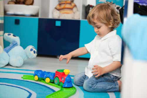 A 2-year-old playing with a toy train.