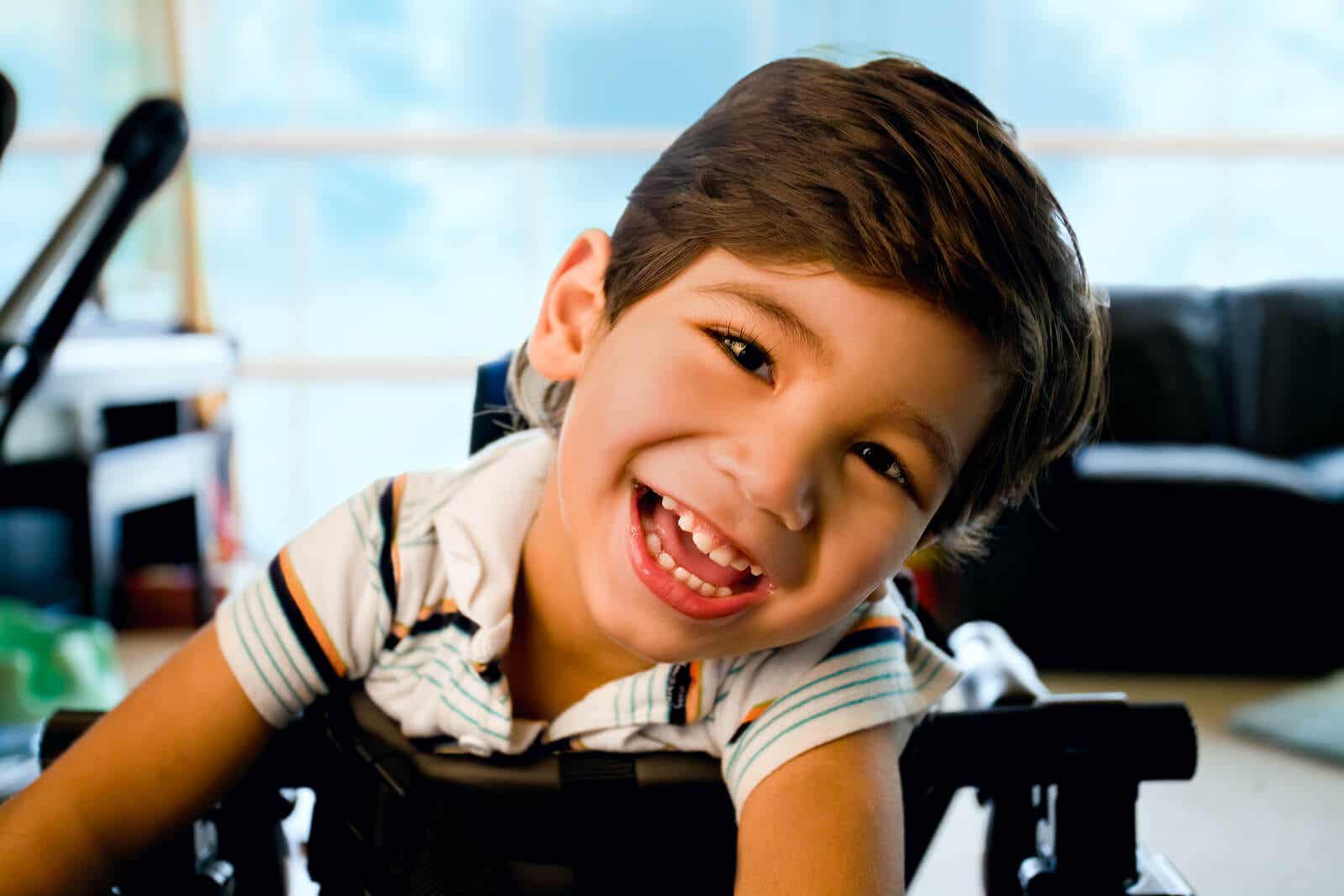 A smiling child leaning on his walker.