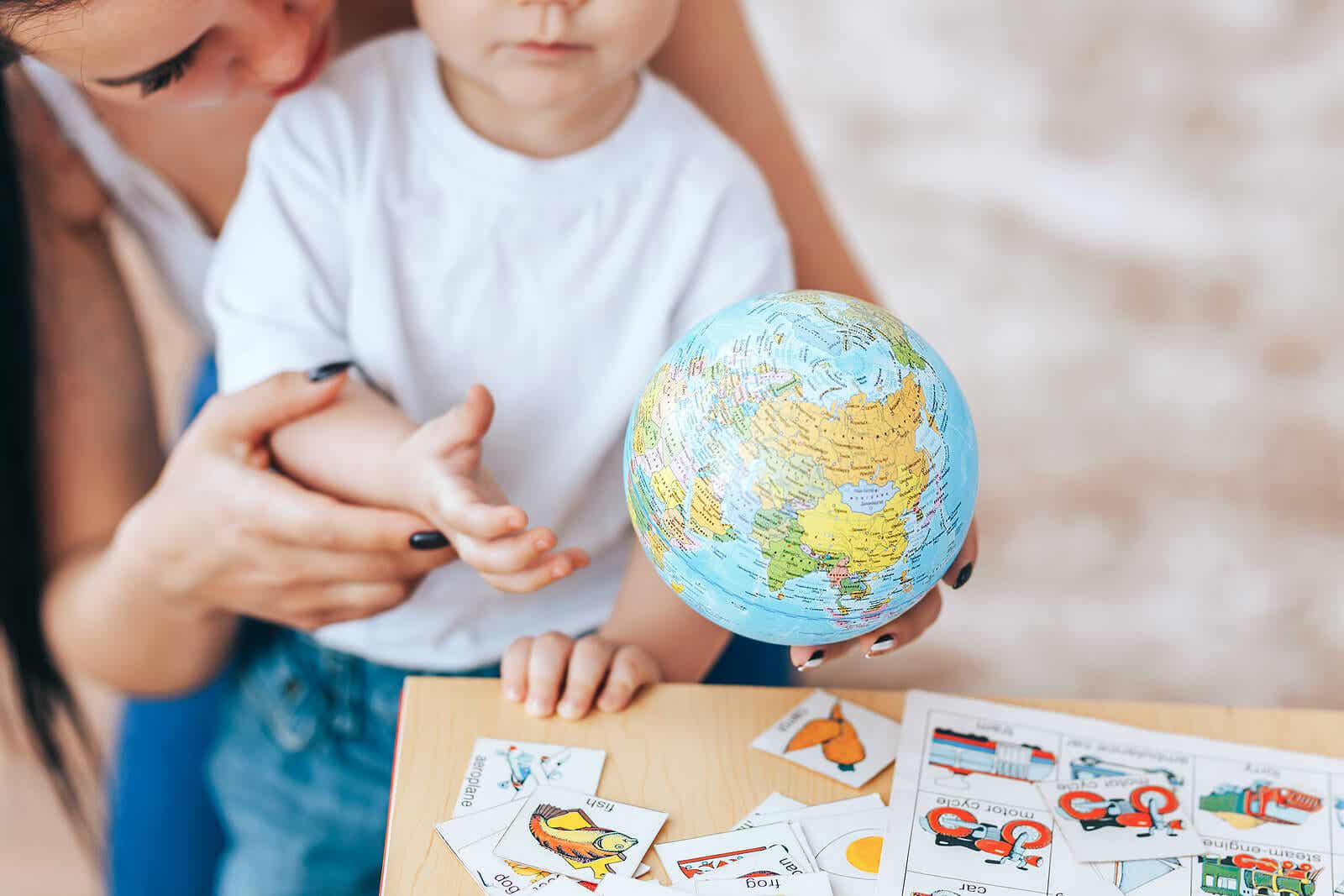 A mother showing a globe to her toddler son.