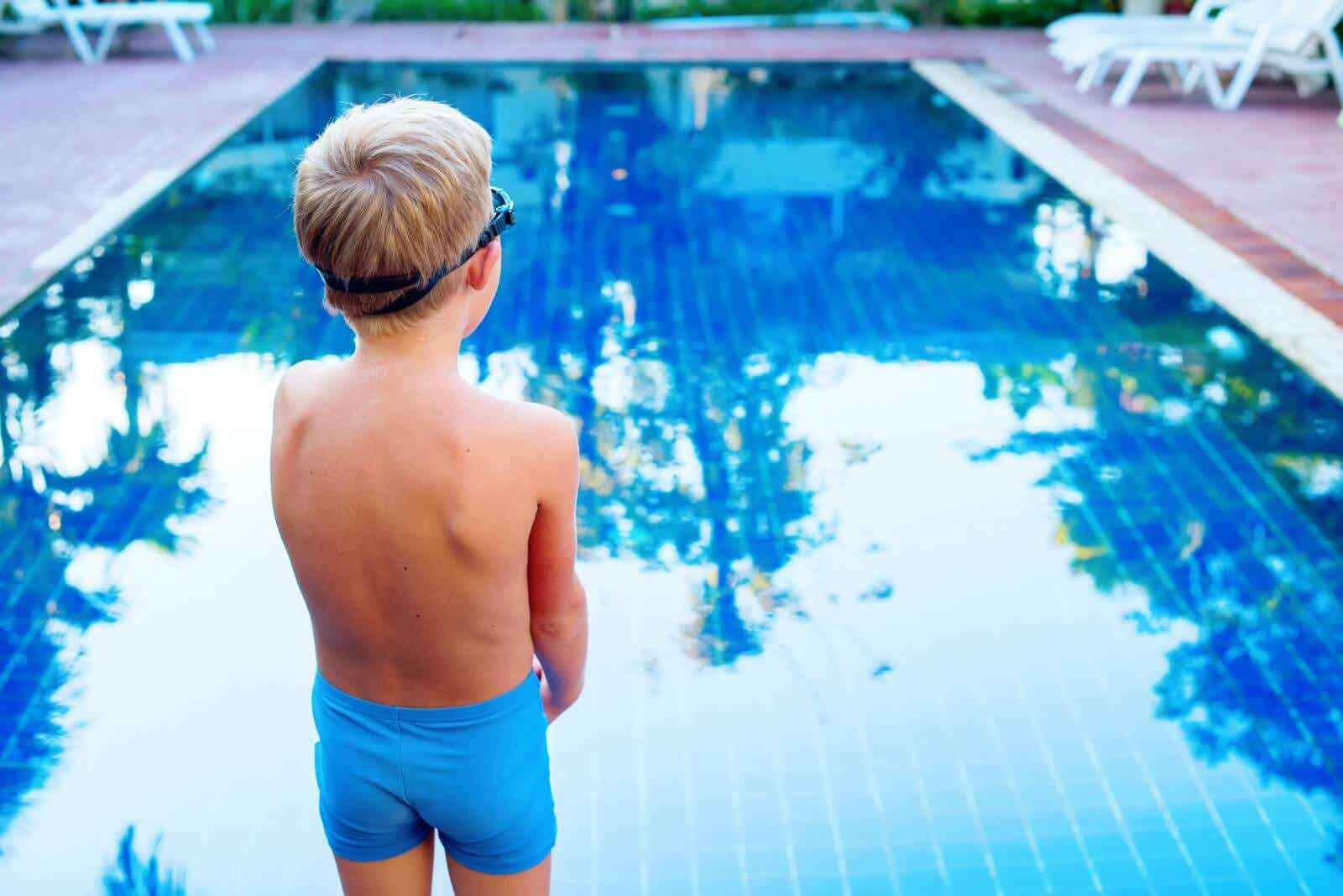 A child standing on the edge of a pool.