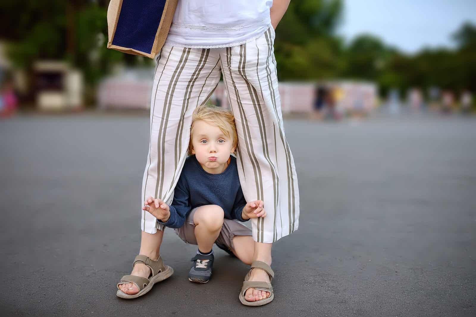 A child peeking our from under his mother.
