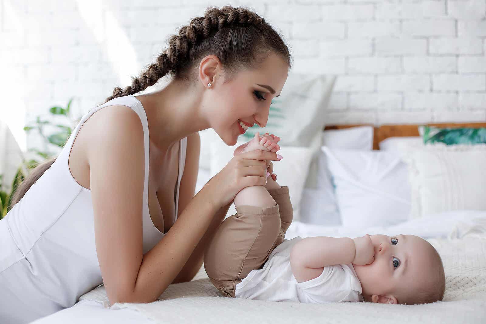 En mamma som leker en bebis fötter och tar hand om sitt barns känslomässiga behov