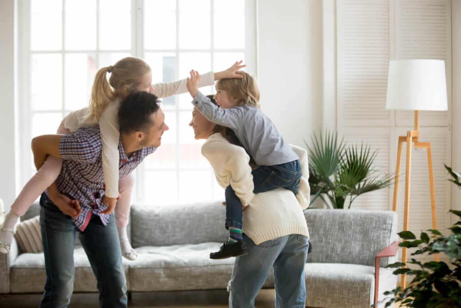 Parents playing with their children in their living room.