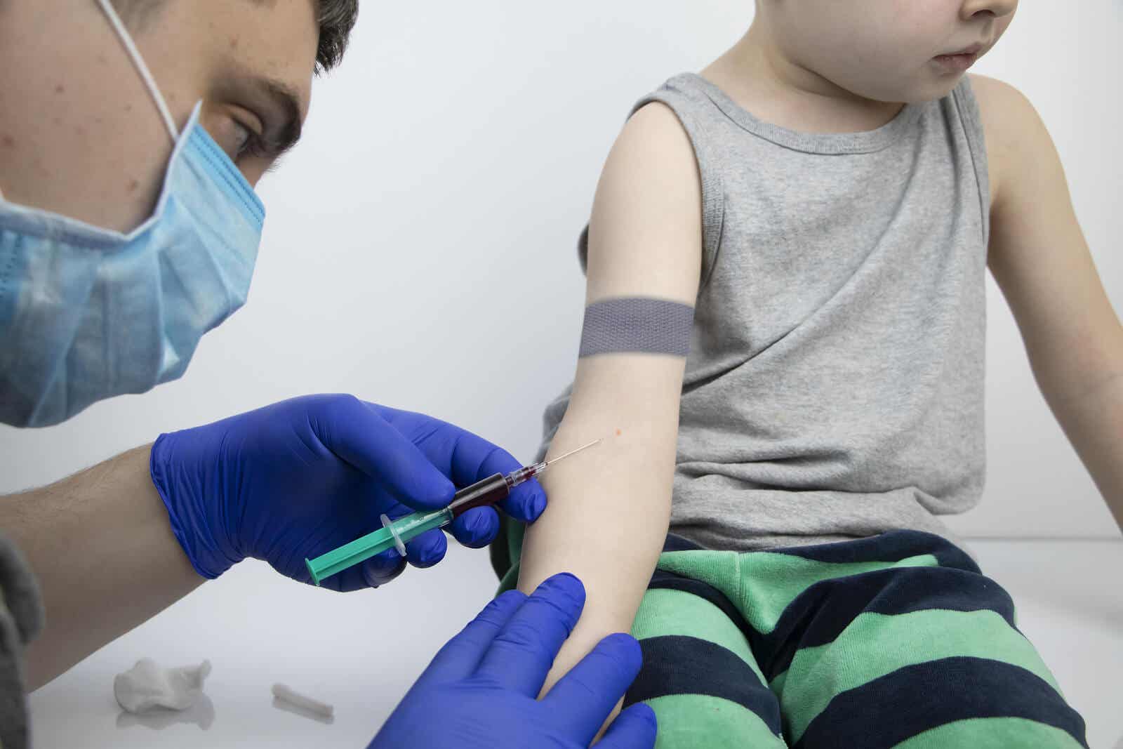 A doctor drawing blood from a child's arm.