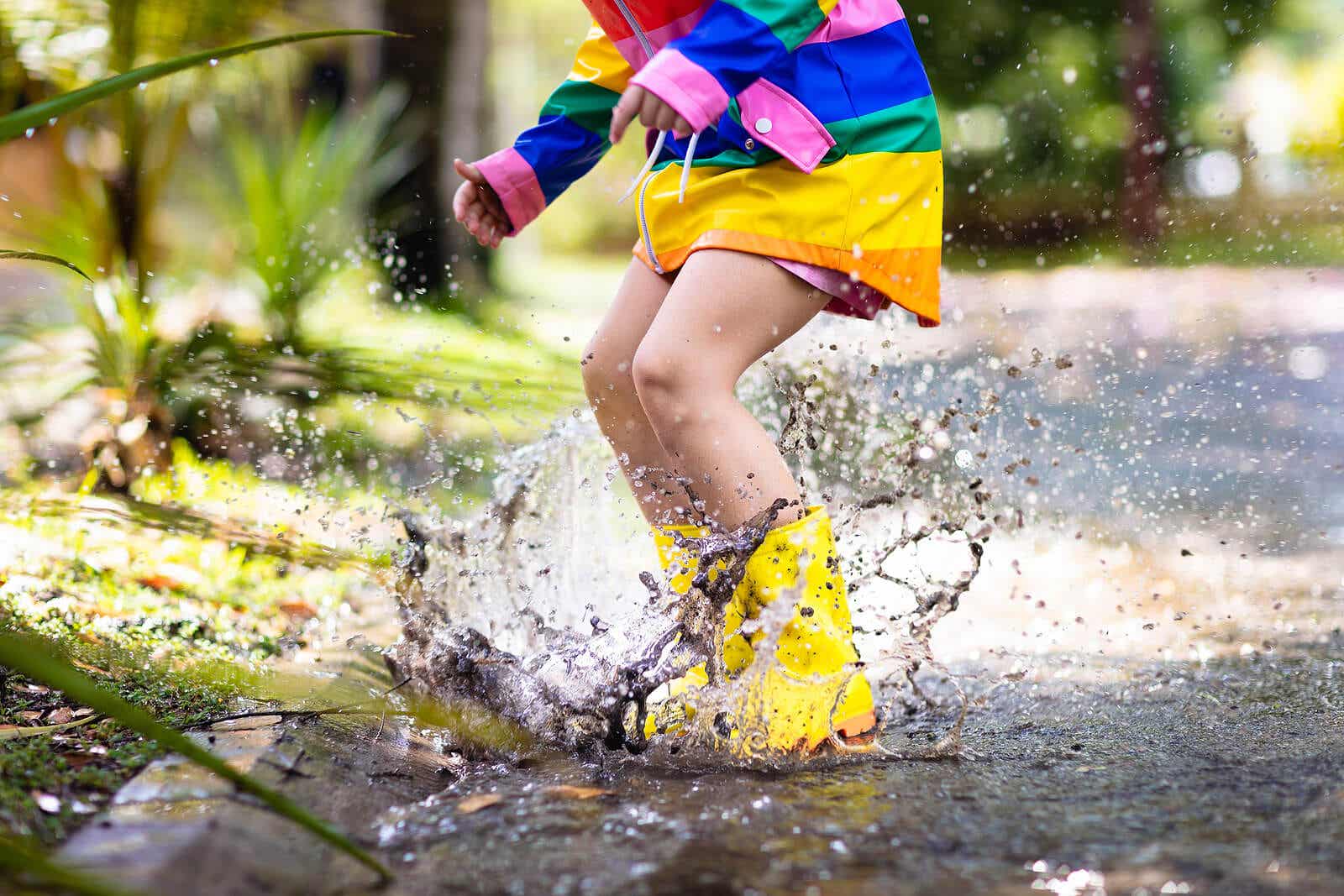 Barn hopper i vandpytter som eksempel på at blive beskidte under leg