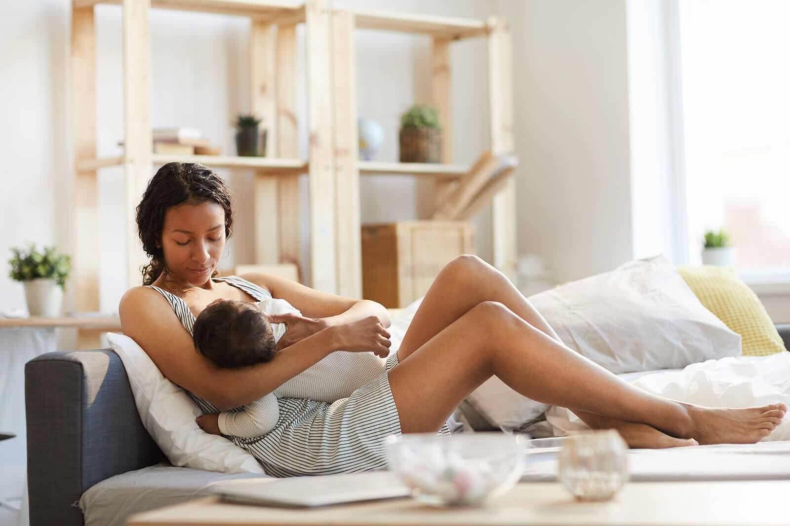 Moeder die haar baby borstvoeding geeft.